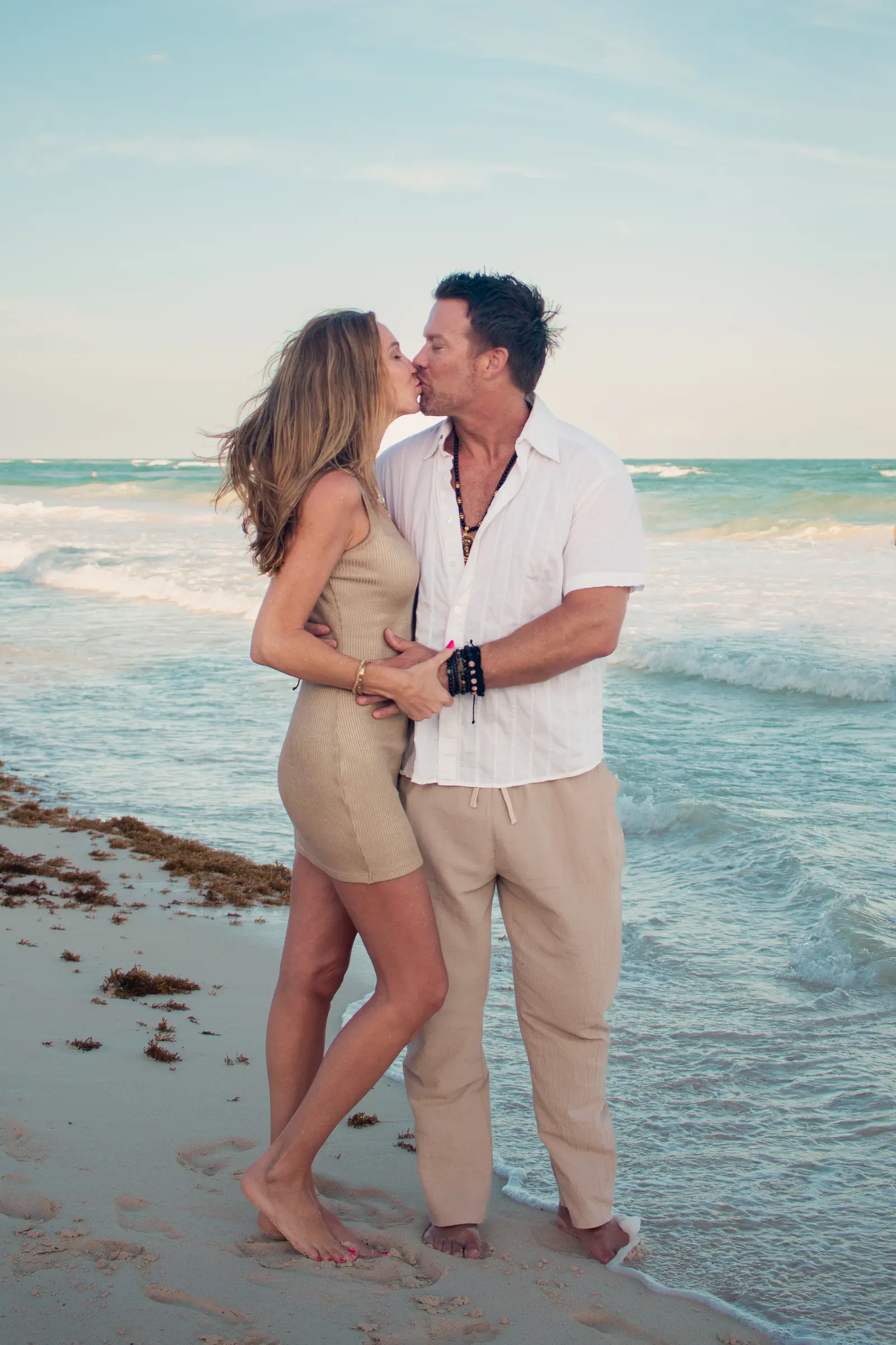 Couple embracing surrounded by tropical scenery during professional Tulum photography session