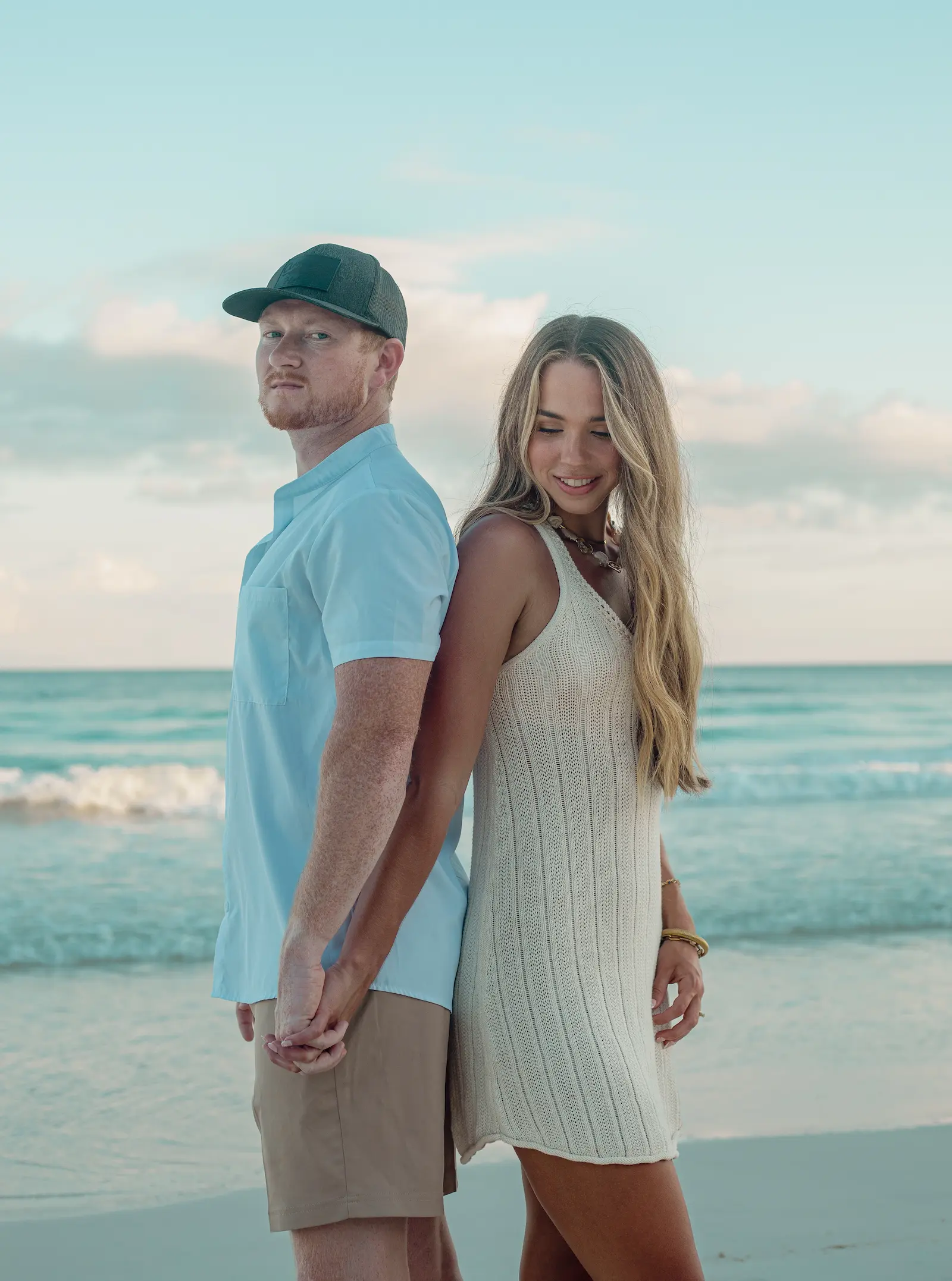 Surprise beach proposal in Tulum with tropical palms and ocean in the background