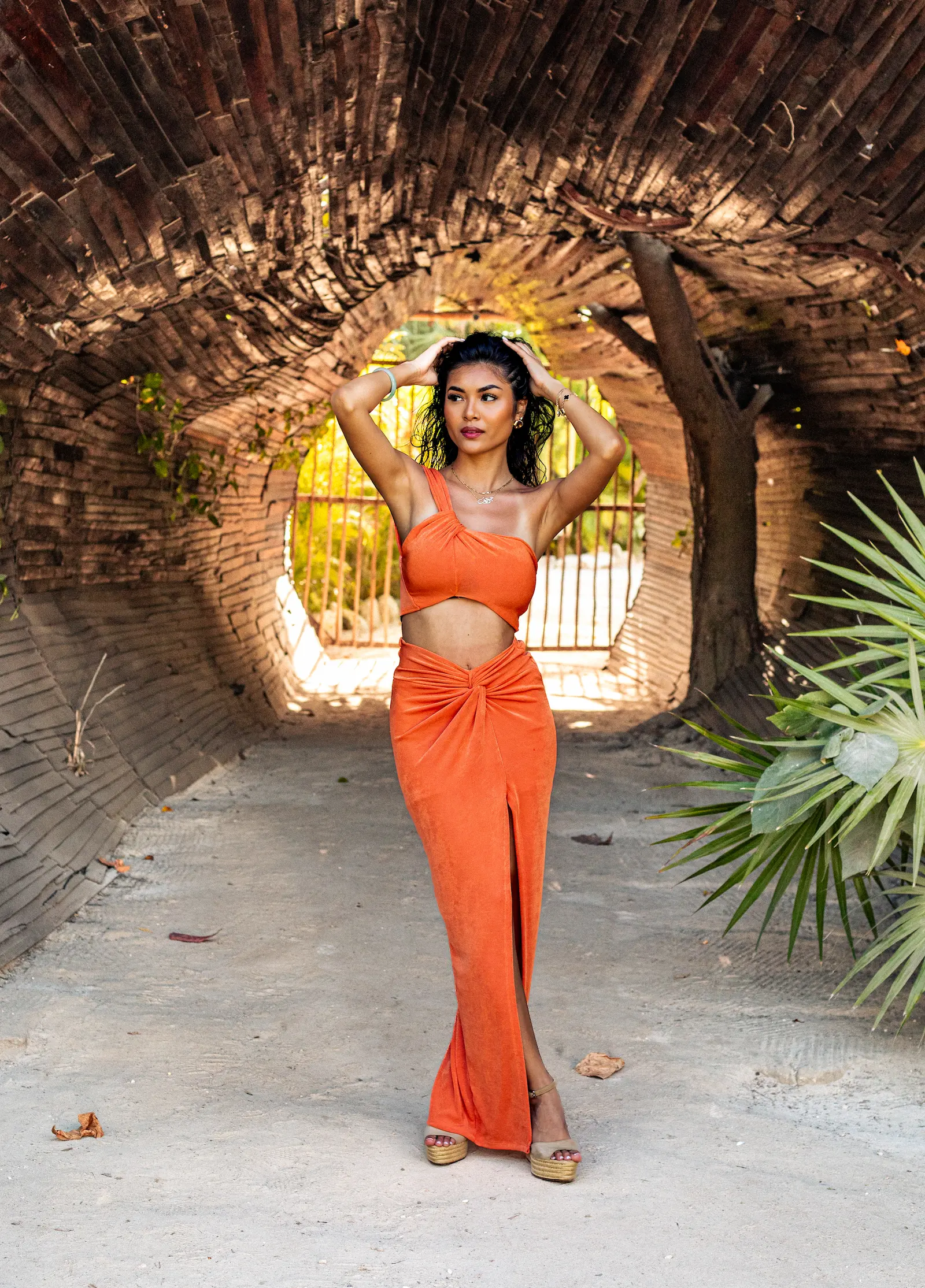 Soft pastel sunset photoshoot in Tulum featuring woman in flowing dress on beach