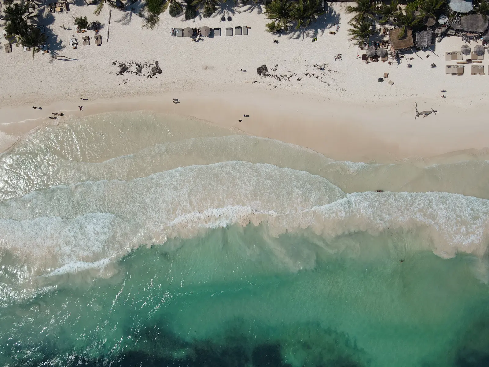 Tulum photographer with drone capturing aerial portrait on Caribbean beach at sunrise